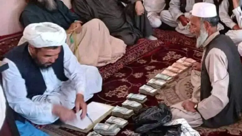 طالبان بین مهاجران افغانستانی اخراج شده پول و غذا توزیع کرد + عکس